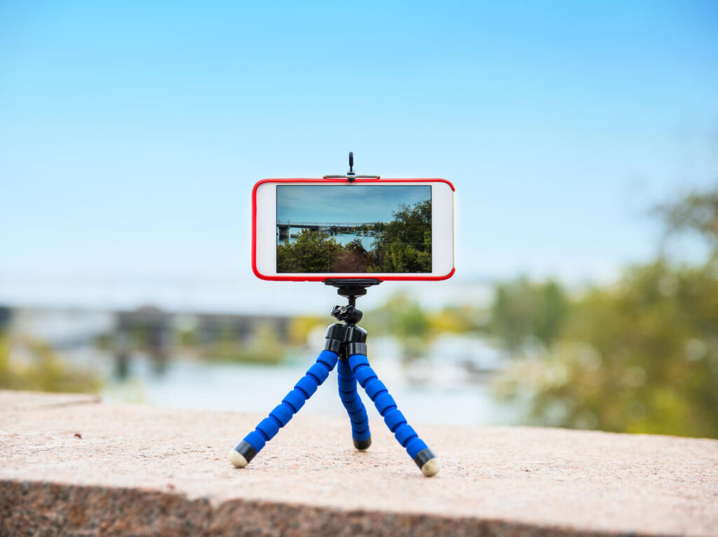 smart phone stands on a tripod and takes a panorama of nature