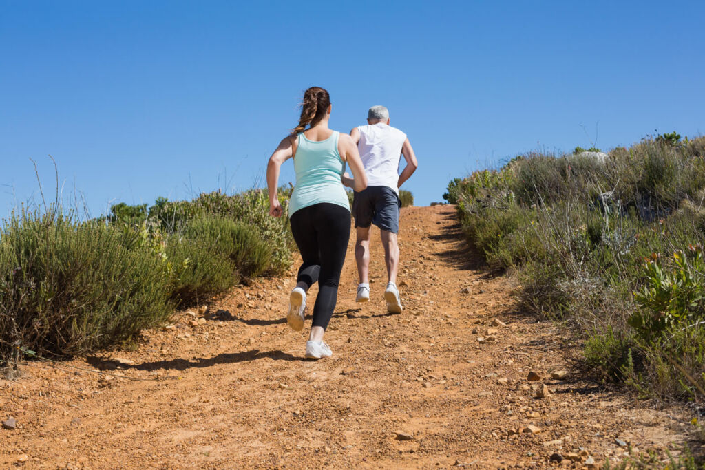 Fit couple running up the mountain trail
