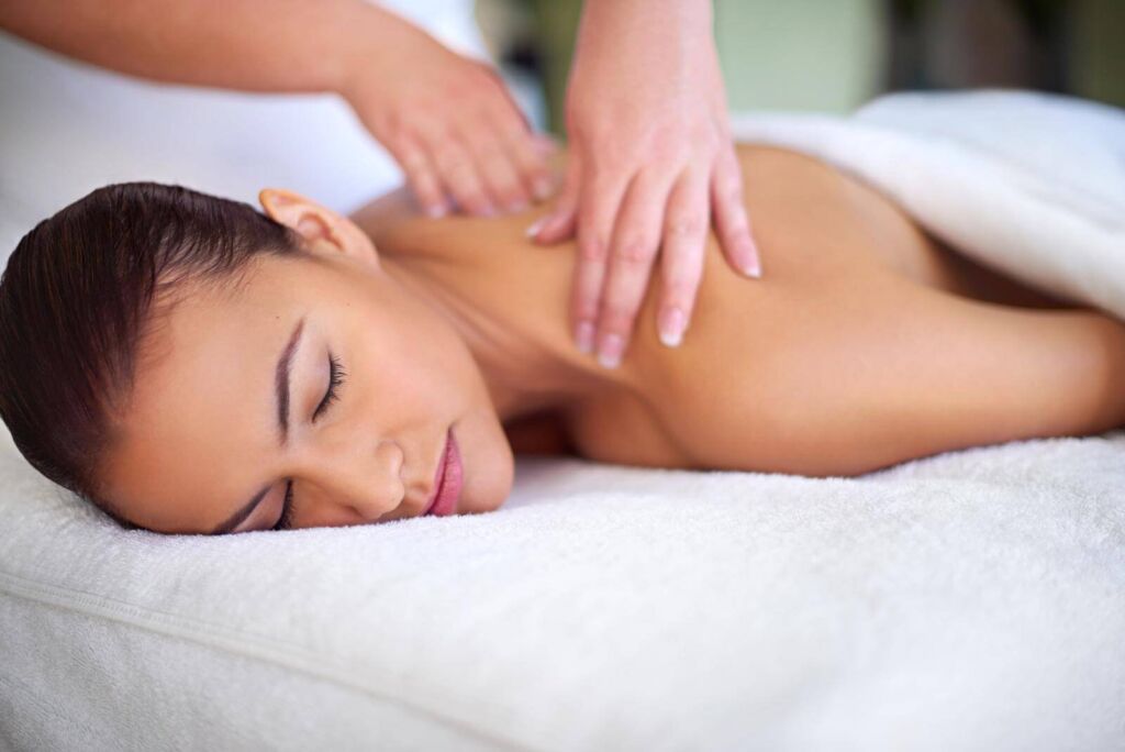 A young woman enjoying a back massage at a spa